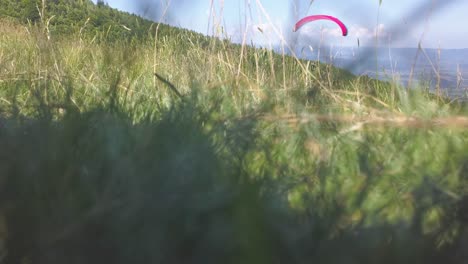 Parapente-Volando-De-Izquierda-A-Derecha-Hacia-El-Valle-De-Abajo