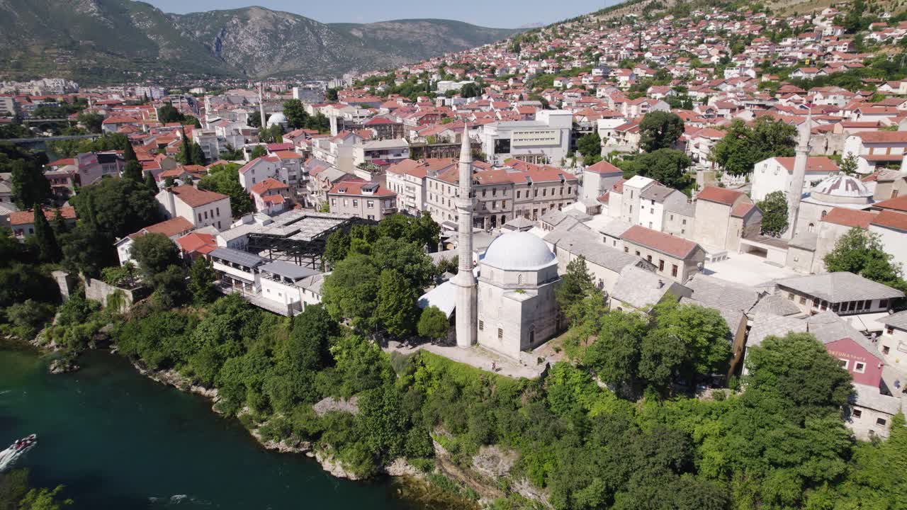 Aerial: Mostar's Koski Mehmed Pasha Mosque riverside view, Bosnia