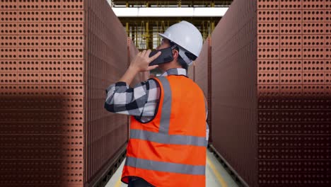 factory worker on phone in brick storage area
