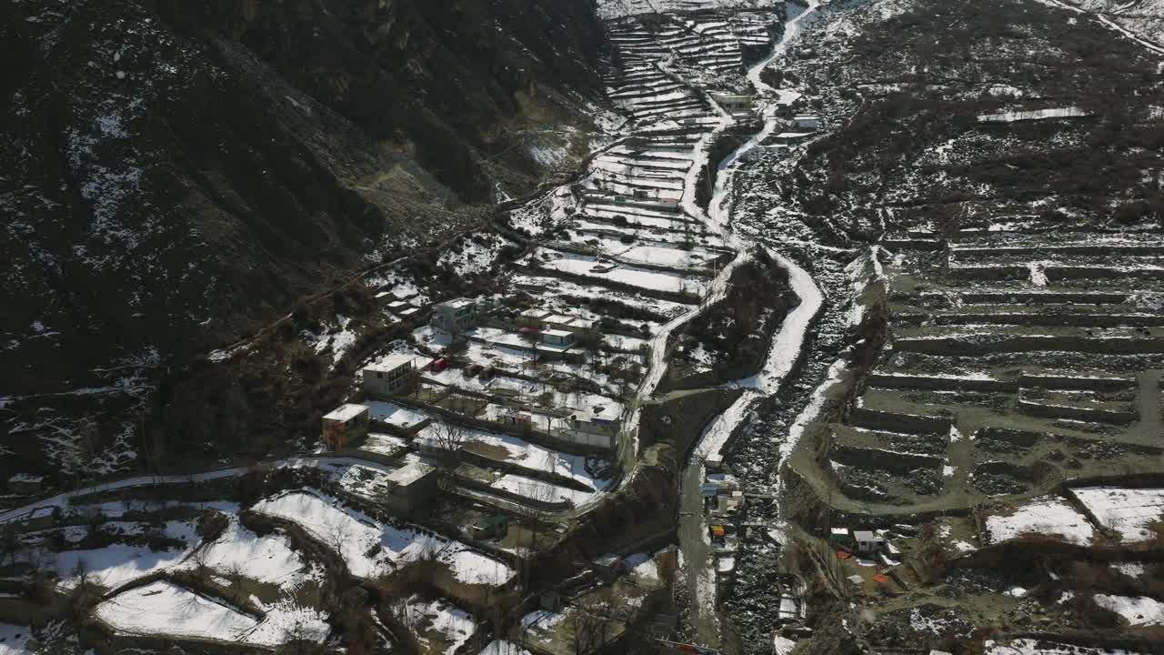 drone volando sobre terrazas cubiertas de nieve en el valle de hunza