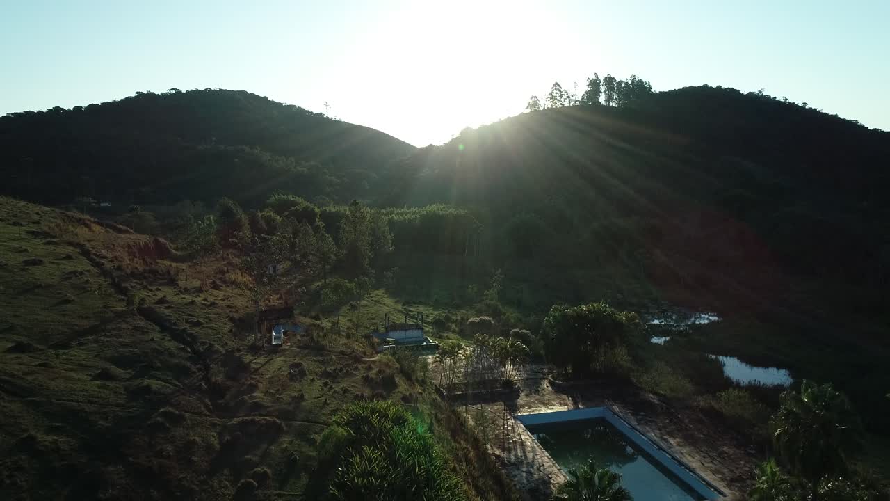 Against light with lateral movement and forward in the late afternoon with beautiful flare in a lush green mountain landscape, peace, calm, tranquility, in 4K resolution