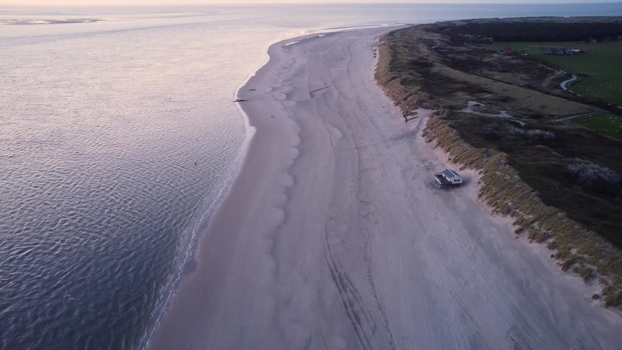 la playa cerca de hollum en la isla de ameland con un bonito resplandor rosado de la puesta de sol en el metraje