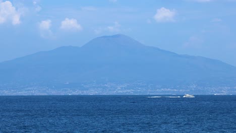 a boat sails across the sea near mount vesuvius