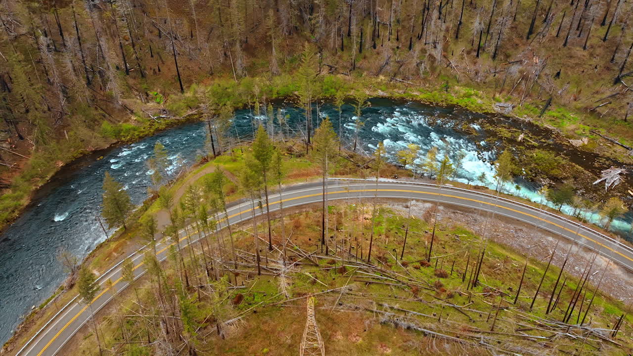 Rapid mountain river flowing along the highway in the mountains. Top view on the rocks with poor vegetation.