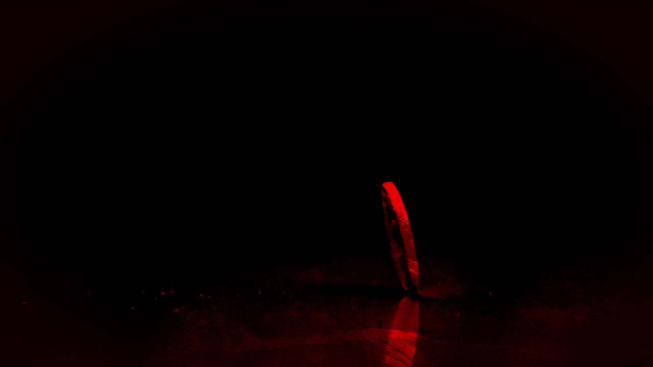 Coin spinning with red light on black background