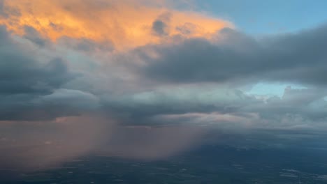 Aeral-view-from-a-jet-cockpit-approaching-to-Seville-airport-of-a-huge-cumuloninbus-while-rainning-with-orange-clouds