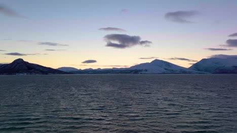 hermoso paisaje escandinavo de una puesta de sol detrás de las montañas y el mar