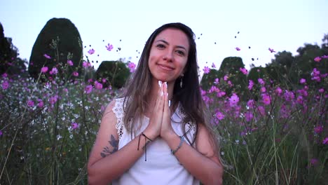 young-latin-woman-smile-to-the-camera-in-the-middle-of-a-beautiful-purple-field-with-tinny-flowers