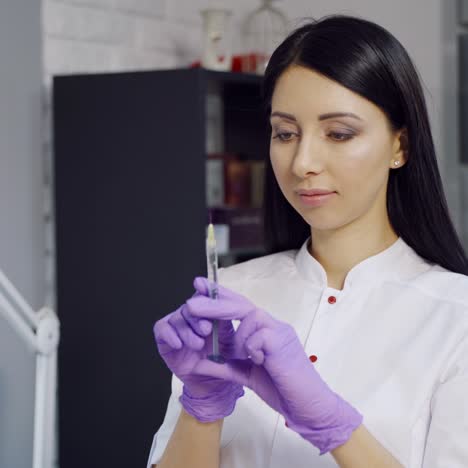 an experienced cosmetologist in gloves holds a syringe with an injection for a cosmetic procedure and checks it. modern methods of aesthetic medicine