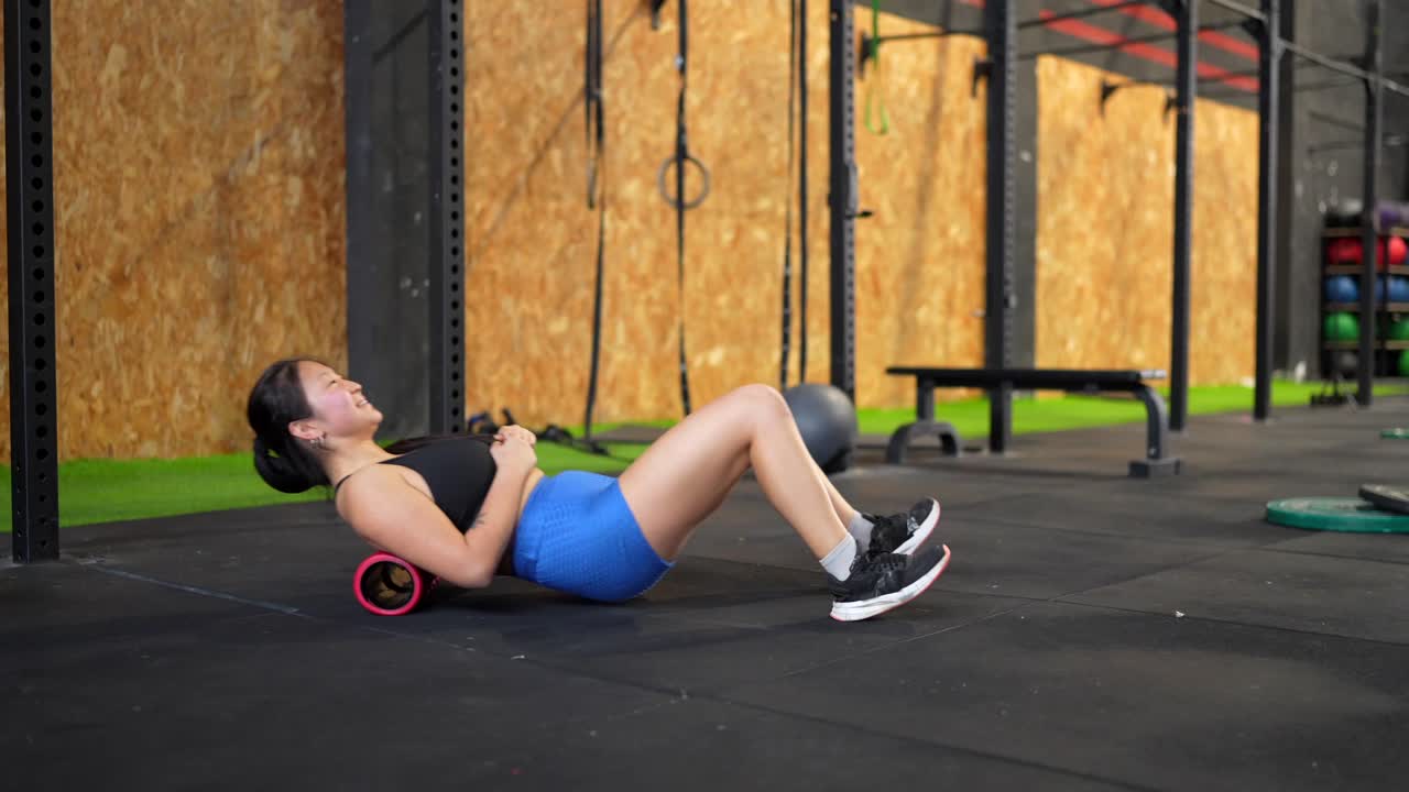Woman using foam roller in gym