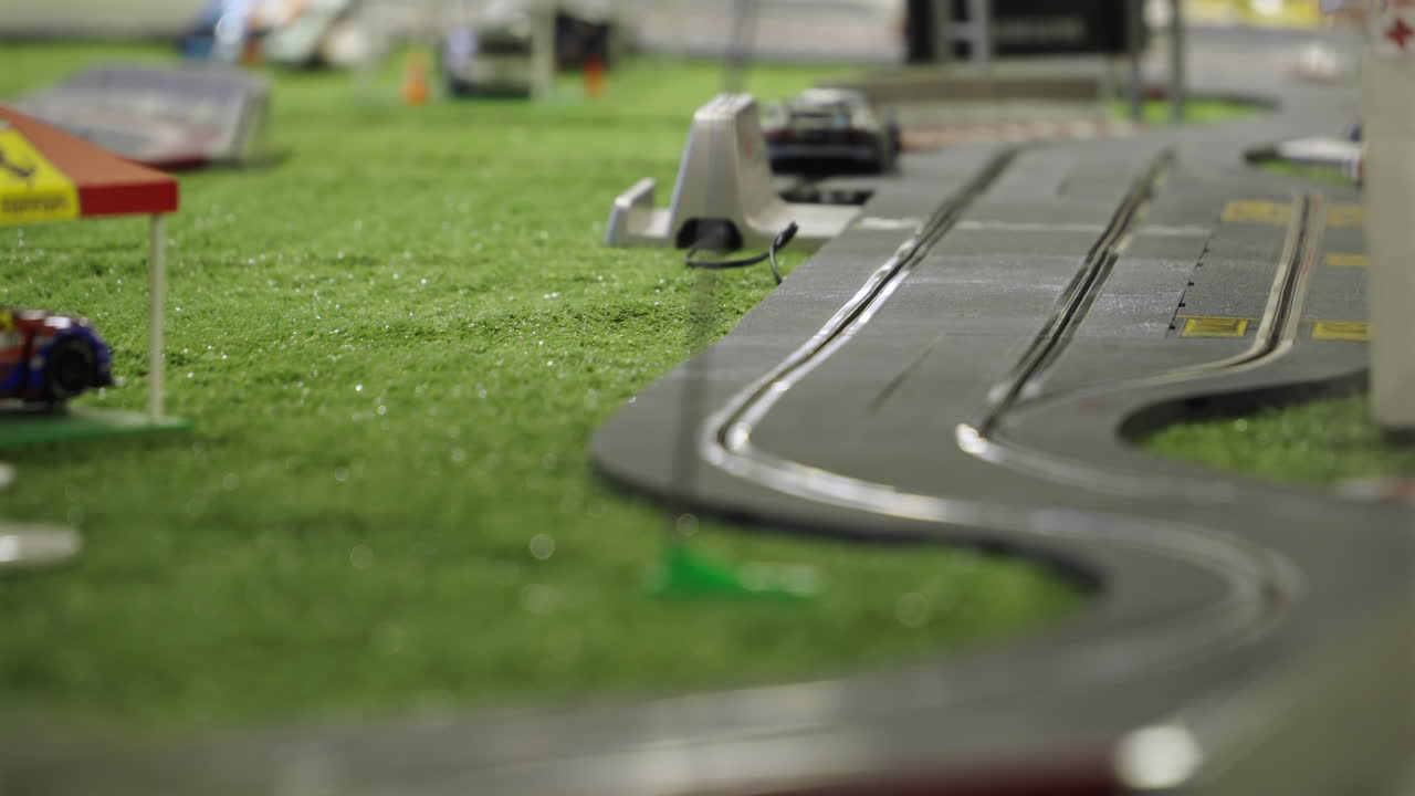 Miniature race cars on playful toy track, fast-paced fun with model scenery