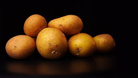 varias patatas giran frente a un fondo negro