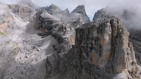 espectacular formación rocosa de las montañas brenta durante el día nublado en el cielo en italia - vuelo de drones