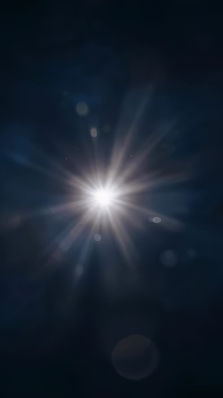 Vertical video: Appearing central light pulsing starburst rays on dark backdrop, from lens optics
