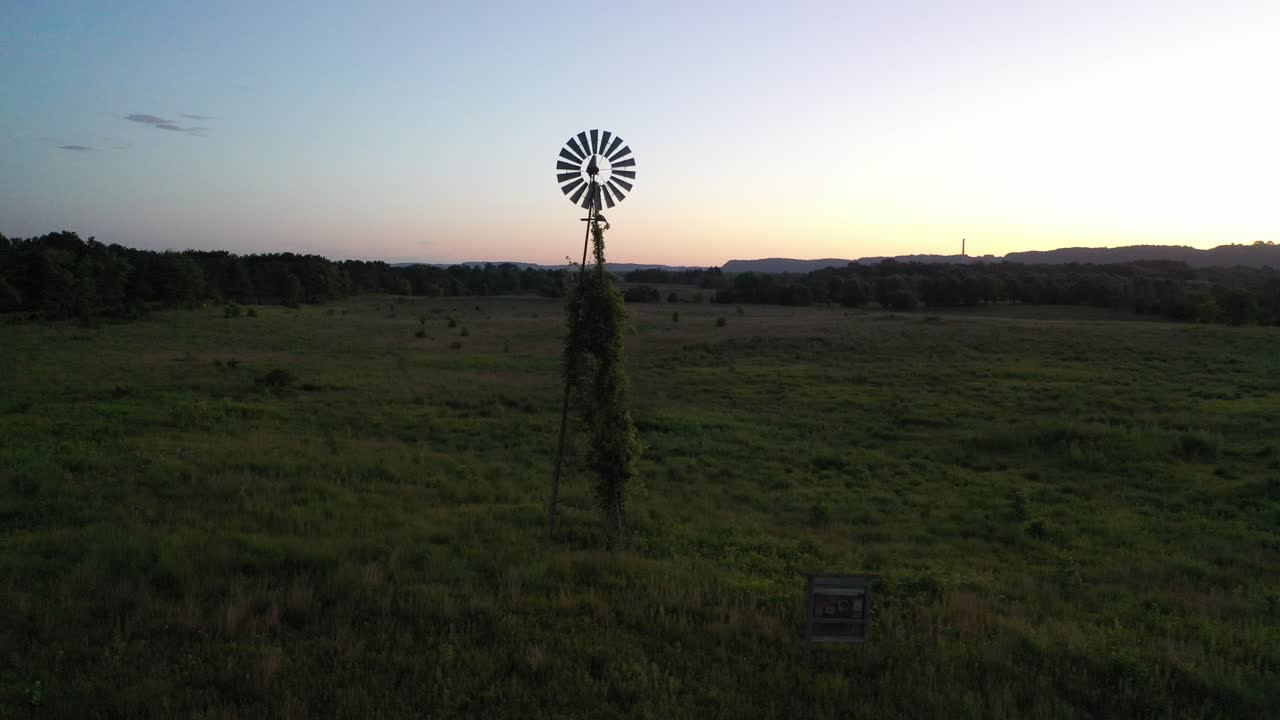 해가 지는 시골 들판 에 있는 풍차