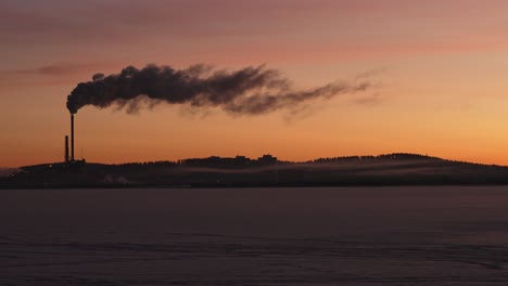 Silhouette-of-smoking-power-plant-in-beautiful-morning-sun,-dolly-in