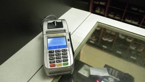 used credit card scanner on old bowling center counter top, closeup dolly out