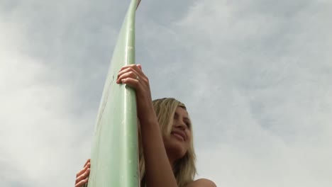 mulher segurando uma prancha de surf