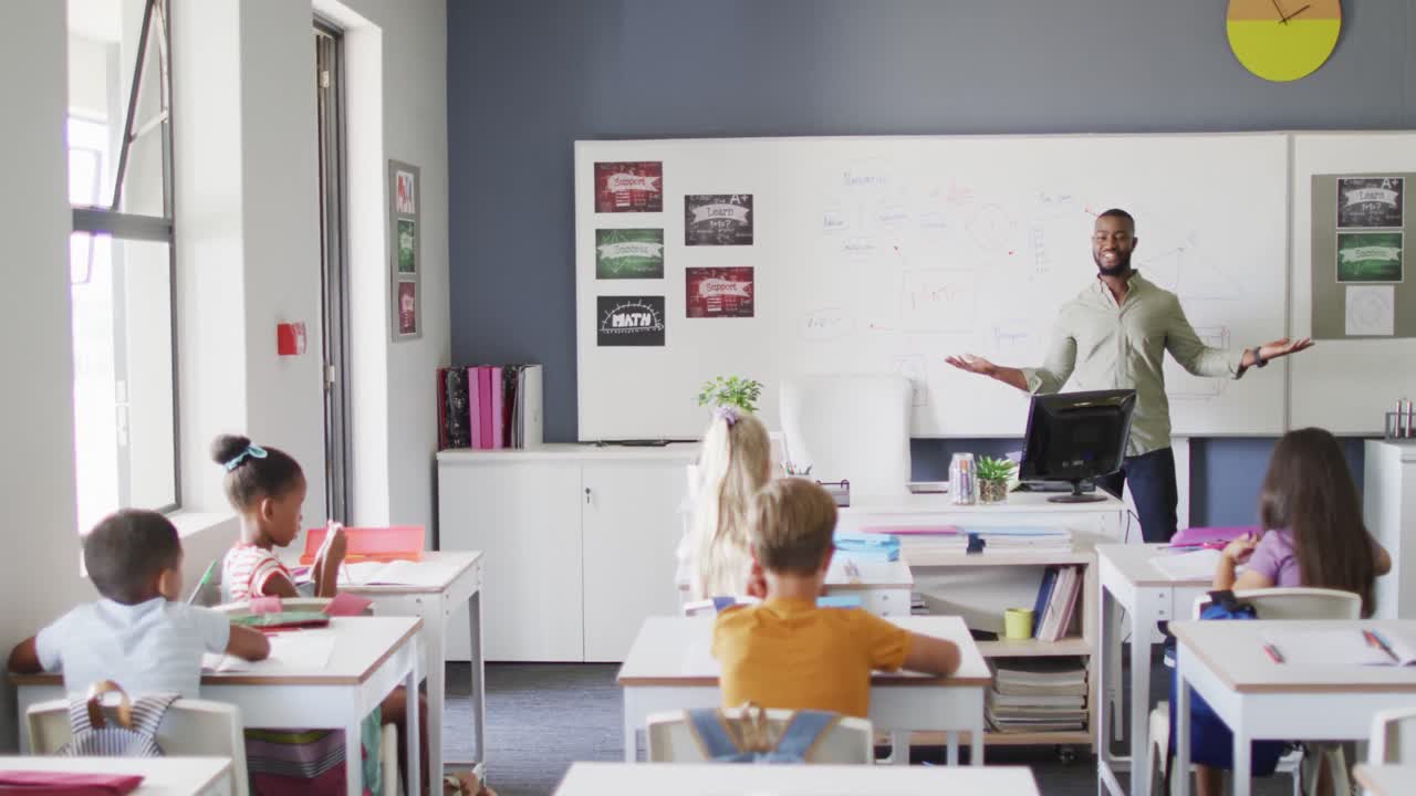 video de un feliz maestro afroamericano durante la lección con una clase de alumnos diversos