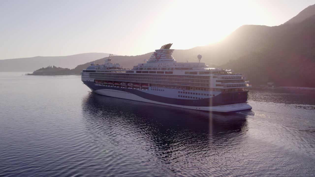 Luftfoto af krydstogtskib i Kotorbugten ved solnedgang i Tivat, Montenegro med betagende solnedgangsbelysning, rolig atmosfære, droneoptagelser i høj kvalitet der indfanger fredfyldte øjeblikke