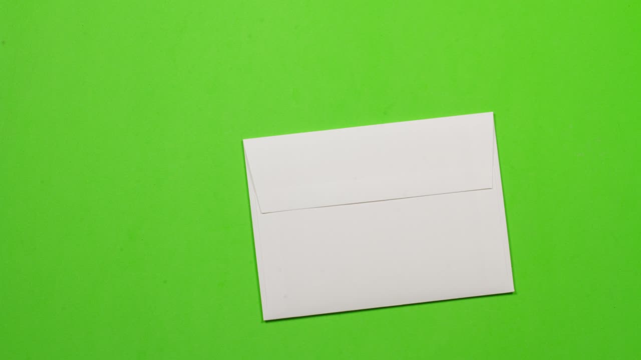 Animazione in stop motion di un foglio di carta giallo che si piega e entra in una busta bianca. Poi esce dallo schermo a destra.