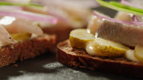 open-faced sandwiches with herring, pickles, and onions