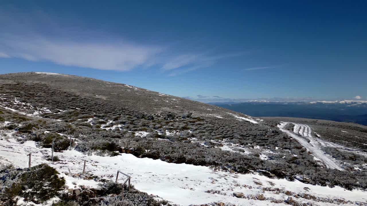 Ripresa panoramica su una montagna innevata e con il mare all'orizzonte a Manzaneda, Galizia.
