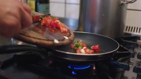 the cook is pushing the vegetables into the pan