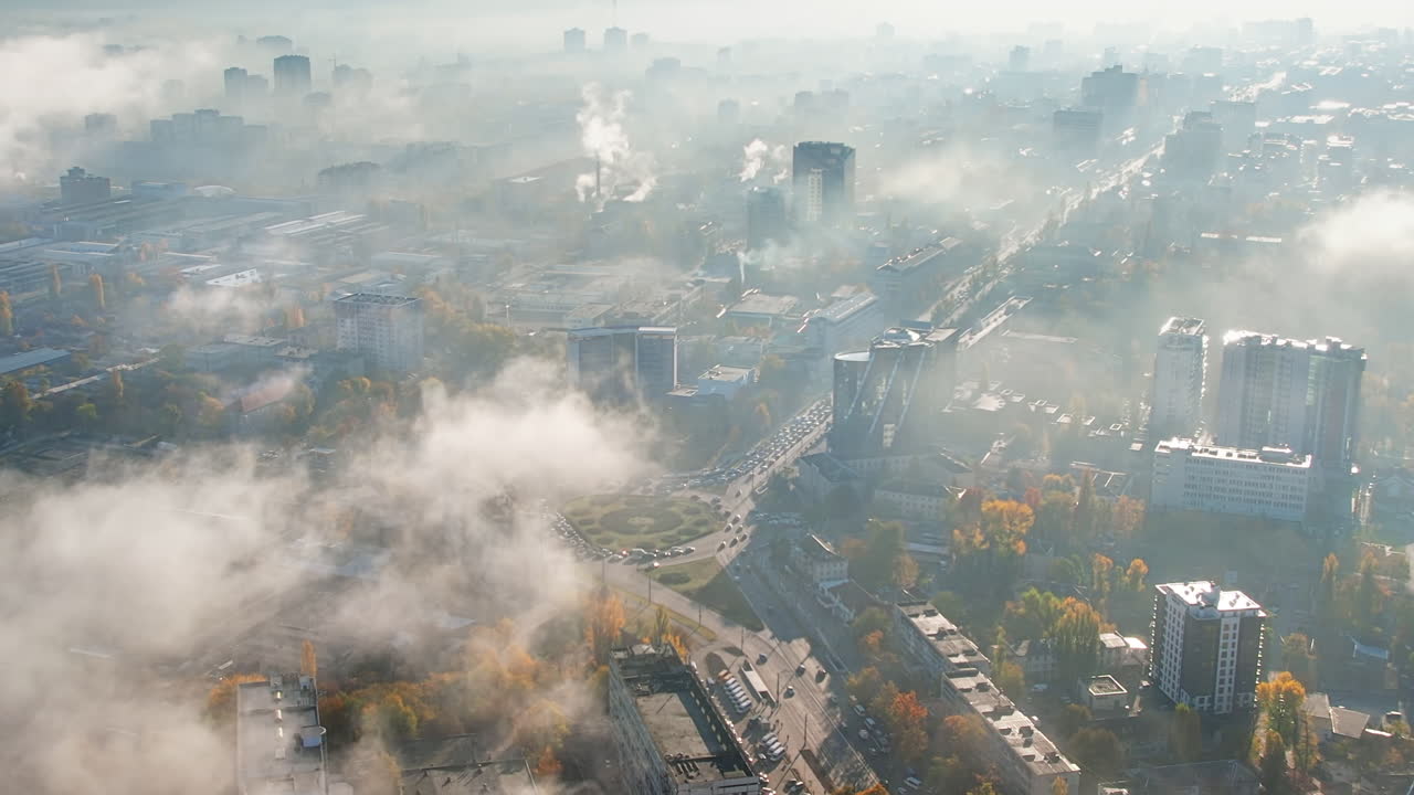 Aerial drone view of Chisinau at sunrise, Moldova. View of the city with fog in the air, multiple buildings, streets with cars and yellowed trees