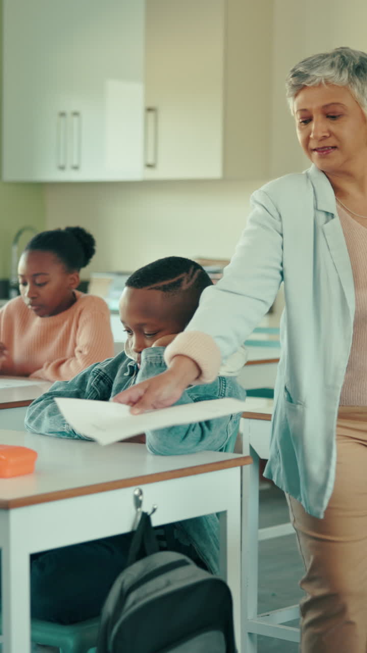 Teacher Handing Out Papers to Young Students in a Classroom