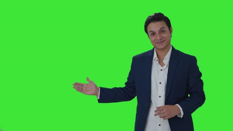 periodista indio feliz señalando el espacio de copia, mostrando el signo de victoria pantalla verde