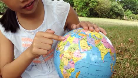 Smiling-girl-looking-at-globe