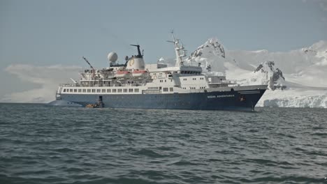 Big-expedition-ship-in-front-of-snow-covered-mountains-and-icebergs