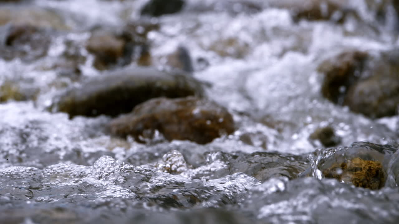 чистый ручей бежит через каменные валуны обильная река течет в замедленном темпе