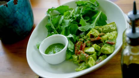 bowl of salad and olive oil bottles on the table in restaurant 4k