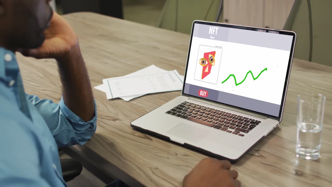 video de un hombre afroamericano trabajando en una computadora portátil con nft en la pantalla