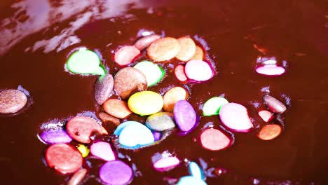 candies fall into a pool of chocolate