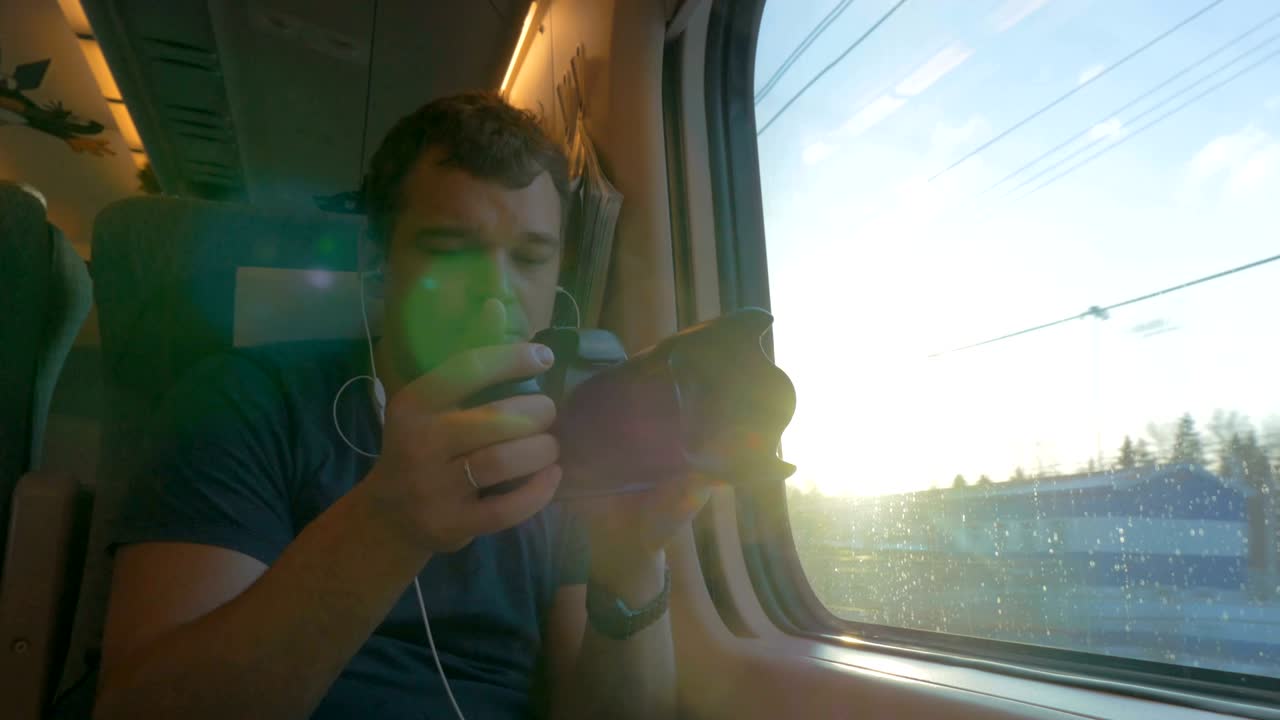 hombre viajero filmando video a través de la ventana del tren