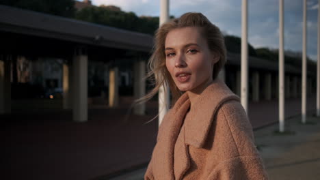 blonde woman looking at the camera outdoors.