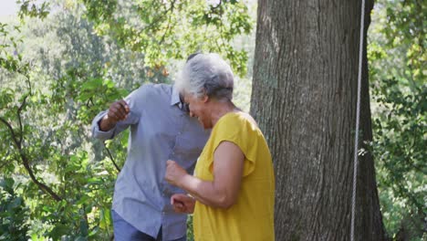 Älterer-Afroamerikanischer-Ehemann-Und-Gemischtrassige-Ehefrau-Tanzen-Und-Lachen-Gemeinsam-Im-Garten