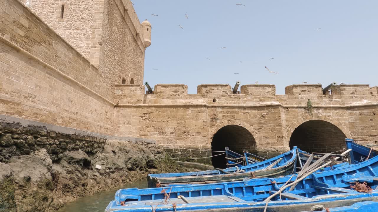 vista panorámica hacia abajo de la fortaleza en essaouira, marruecos y los famosos barcos de pesca azules