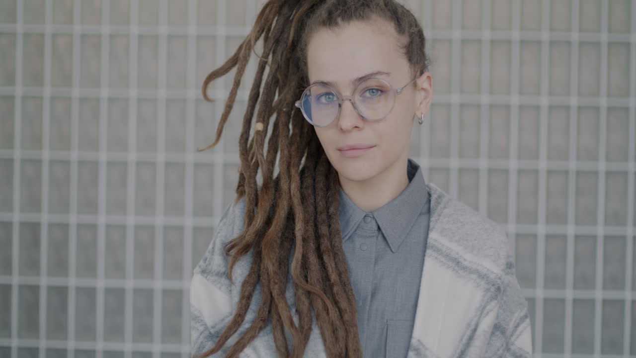 Portrait of a woman with dreadlocks and glasses