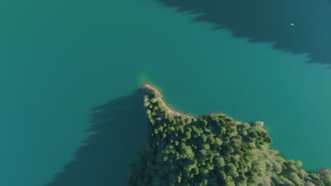 aerial view of a turquoise lake with a forested island