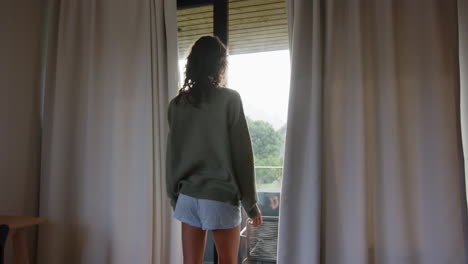 Stretching in front of window, woman enjoying morning at home retreat