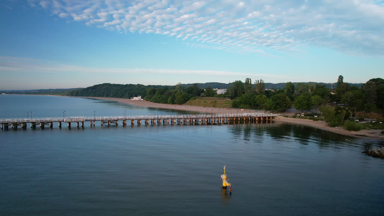 Gdynia Orlowo Wooden Pier Molo With Beautiful Sandy Beach Coastline at Sunrise in Summer - Aerial Panning