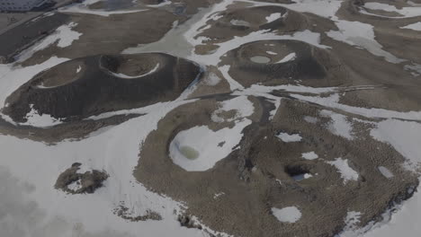 drone shot of snow capped volcanic formations, craters and calderas in landscape of iceland