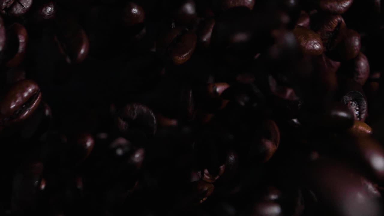 Slow motion bird's eye view shot of coffee beans flying towards the camera from below