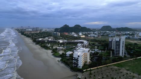 Schöne-Luftdrohnenaufnahme-Eines-Knallstrandes-Und-Der-Gebäude-In-Vietnam-An-Einem-Bewölkten-Tag