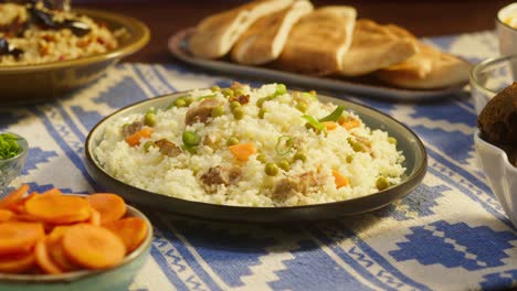 putting cooked couscous with chicken on table close-up. arabian cuisine. pita and bulgur on background. traditional middle eastern culture. delicious rice with meat. homemade food concept