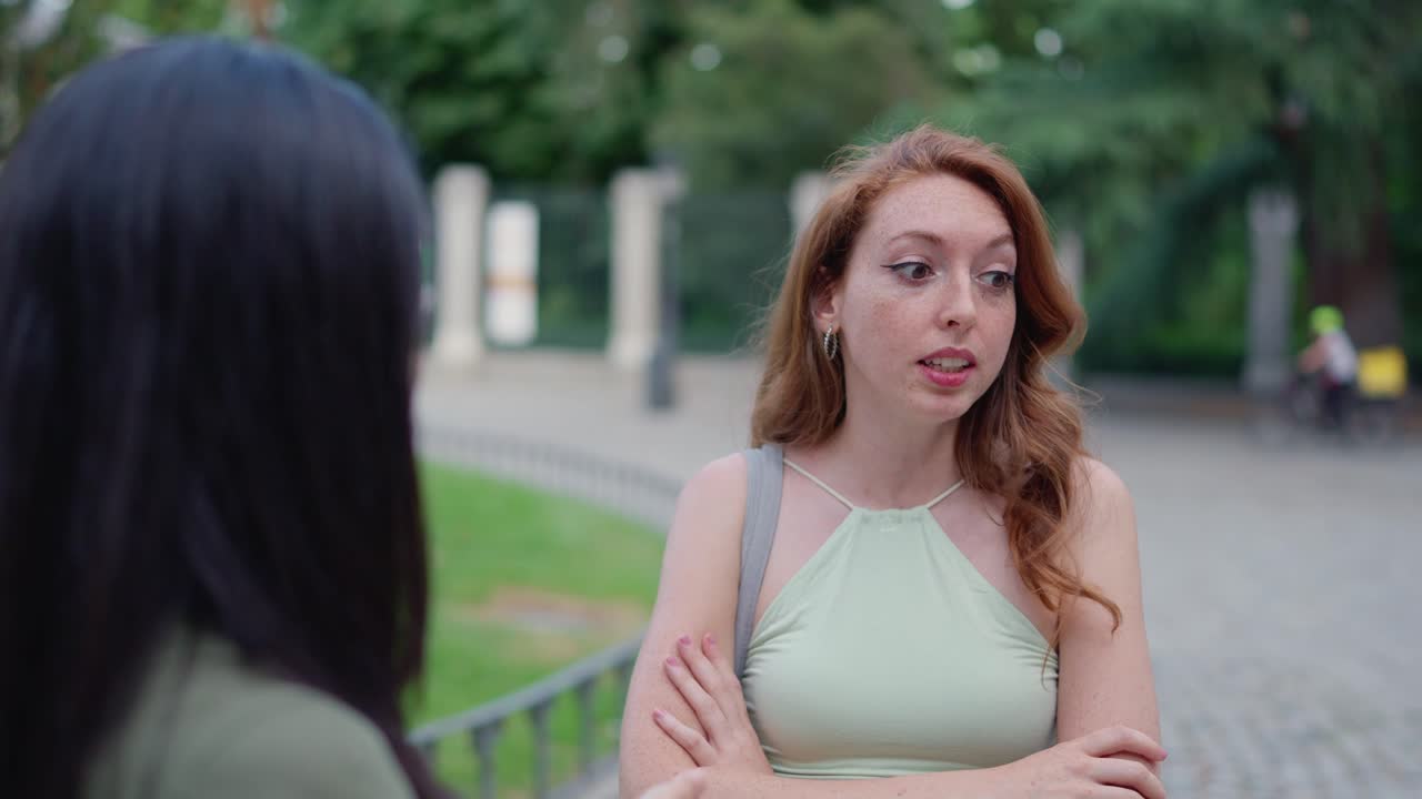 Young woman with red hair reacting during an outdoor conversation